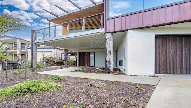 A modern two-story building with a covered outdoor area and a large garage. - Across The Road From The Beach (Inverloch)