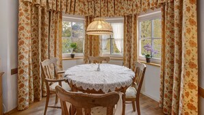 A dining area with a round table, chairs, and a lace tablecloth. - Vacation apartment "Seeberg - House Annamirl" with beautiful south terrace (Bayrischzell)