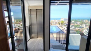 A spacious hallway with a view of the sea and cityscape through large glass doors. - Penthouse Condo with Private Rooftop Terrace. Short walk to the Beach & Malecón. (Puerto Vallarta)