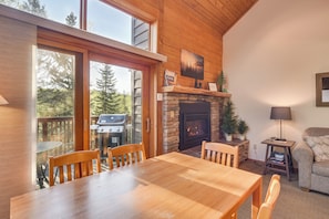 Cozy cabin living space with a large dining table, comfortable sofa, and fireplace.