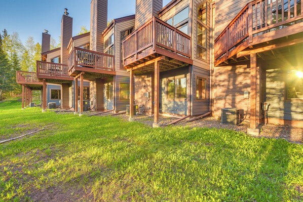Situated in a serene natural setting, this cabin features a multi-story design with spacious balconies and large windows.