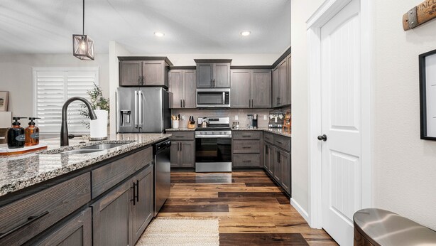 A modern kitchen with dark wood cabinets, stainless steel appliances, and a granite countertop. - Family-Friendly Home Near Vineyards & Dtwn Newberg (Newberg)