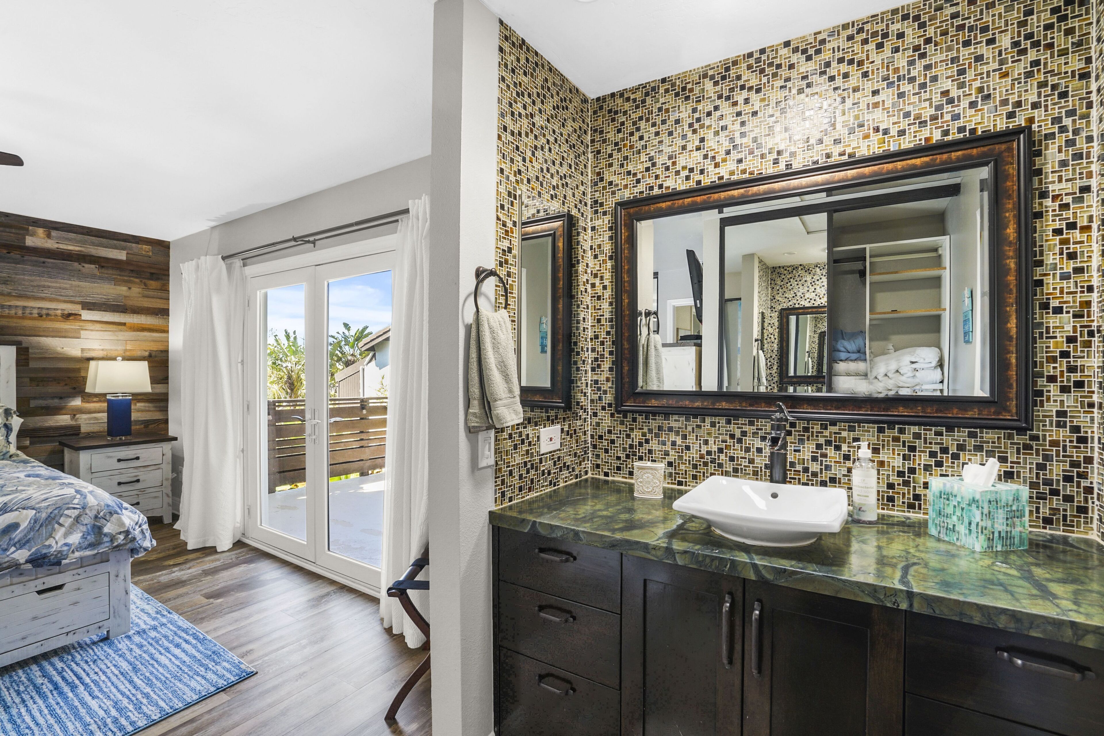 Une salle de bain moderne avec un grand miroir, un lavabo et un espace douche.