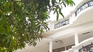 A multi-story building with a white facade and balconies. - Fully Furnished 1BHK Deluxe Suite SA2 - Room, Lobby, Kitchen, bathroom, Terrace (Lucknow)