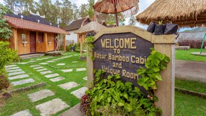 Señal de bienvenida para una cabaña de bambú y una habitación única.
