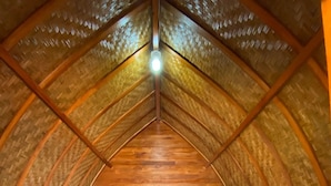 Una habitación acogedora con techo de madera, una cama, almohadas y una mesita.