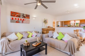 A living room with two sofas, a coffee table, a ceiling fan, and a kitchen area visible through an open door. - Apartment 'Bellavista Port De Soller' with Sea View, Private Terrace and Wi-Fi (Port de Sóller)