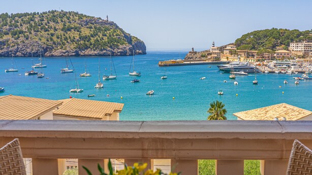 Vista costera con barcos, un faro y edificios.