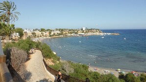 Eine Küstenstadt mit Strand, Booten und blauem Himmel.
