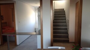 A hallway with a staircase leading to a bedroom with a bed and a small table. - "Fantastic apartment" with Pool, Whirlpool, Wi-Fi, A/C, Balcony & Terrace (Torrevieja)