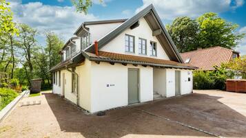 Ein zweistöckiges Haus mit Satteldach, Garage und einem kleinen Anbau.