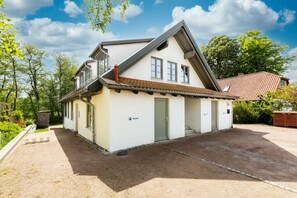 A two-story house with a sloped roof, a garage, and a small attached structure.