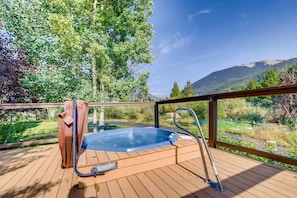 A hot tub on a wooden deck with a view of a forest and mountains. - Platinum Frost Fire, Hot Tub access, Near Slopes! (Keystone)