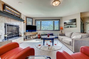 A living room with a fireplace, a television, a sofa, and a coffee table.