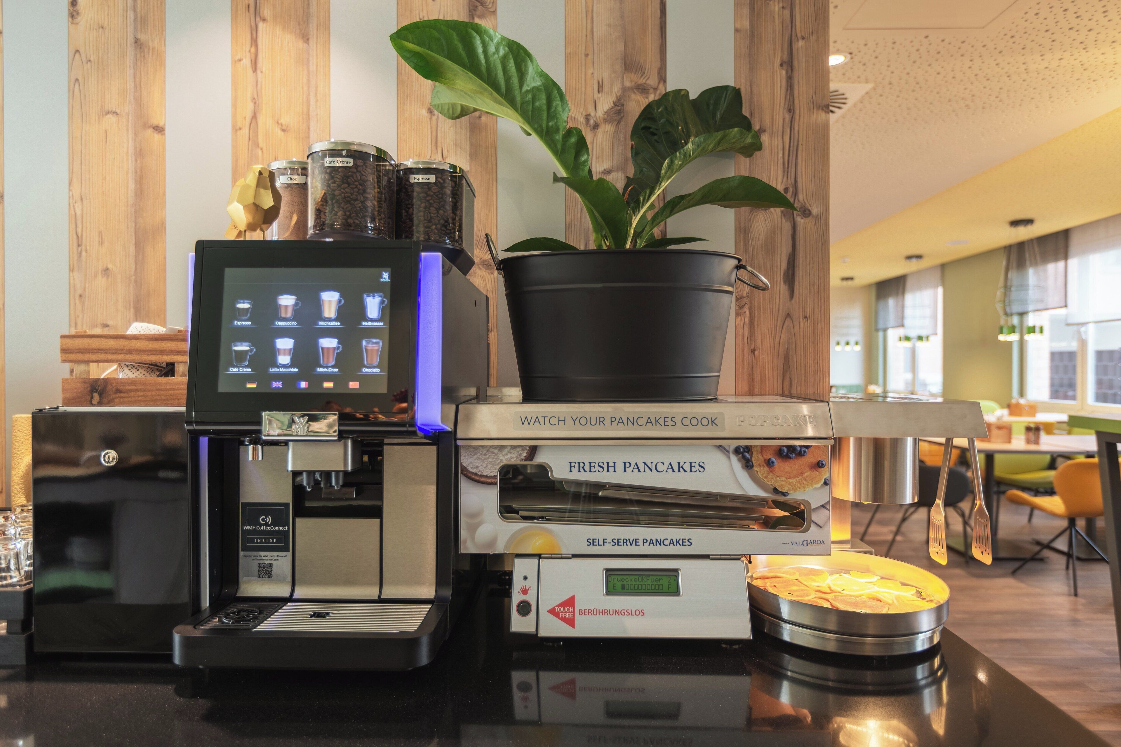 Une machine à café dotée d’un écran numérique et d’un distributeur automatique de crêpes.