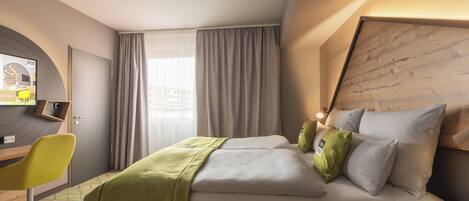 Una habitación de hotel con cama, escritorio, silla y televisor.