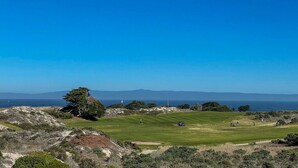 A coastal golf course with a clear view of the ocean and distant mountains. - Saltbox - Pacific Grove House - Two Blocks to Beach and Downtown! (Pacific Grove)
