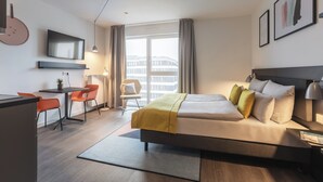 A modern hotel room with a bed, a desk, and a chair. - Candlewood Suites Berlin Charlottenburg by IHG (Berlin)