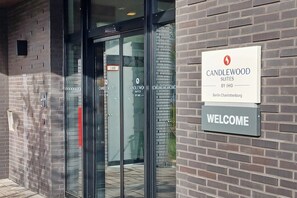 L’entrée de l’hôtel Candlewood Suites, qui fait partie du groupe IHG, à Berlin, se distingue par ses portes en verre et un panneau d’accueil.