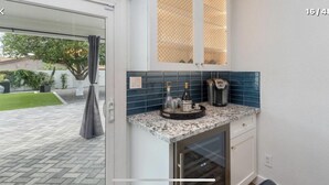 A kitchen with a granite countertop, a coffee maker, and a wine bottle. - Perfectly located in Scottsdale to ALL  (Scottsdale)
