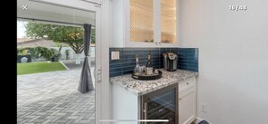 A kitchen with a granite countertop, a coffee maker, and a wine bottle. - Perfectly located in Scottsdale to ALL (Scottsdale)