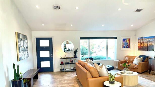 A spacious living room with a large sofa, a coffee table, and a bookshelf. - Perfectly located in Scottsdale to ALL  (Scottsdale)