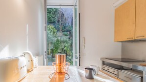 Una cocina moderna con horno empotrado, cafetera y una olla de cobre sobre la encimera.