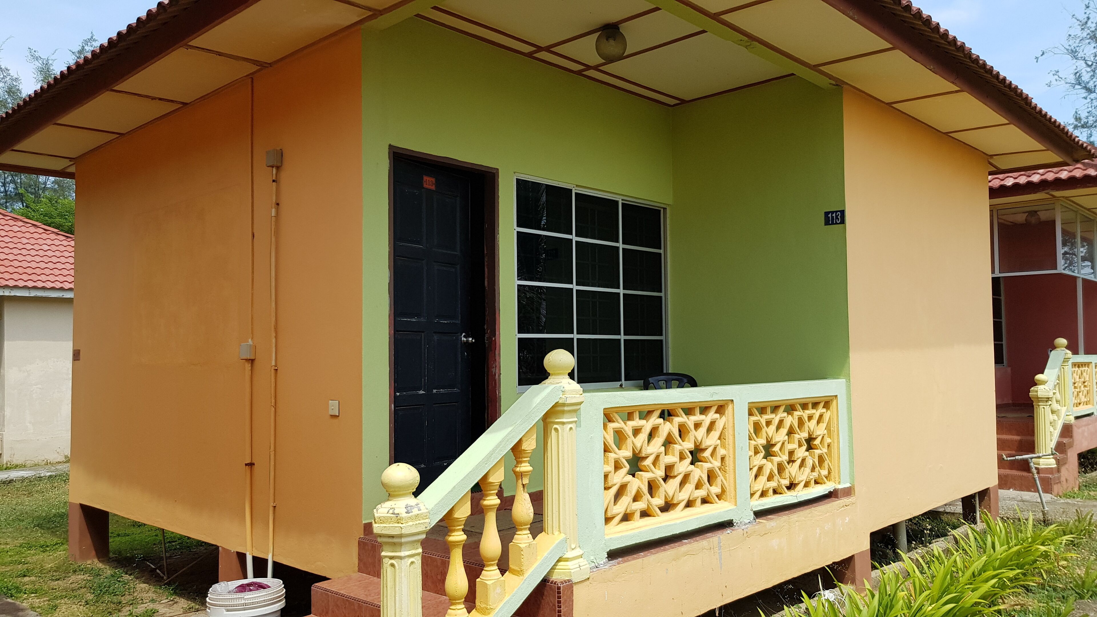 A two-story house with a green upper floor and an orange lower floor.