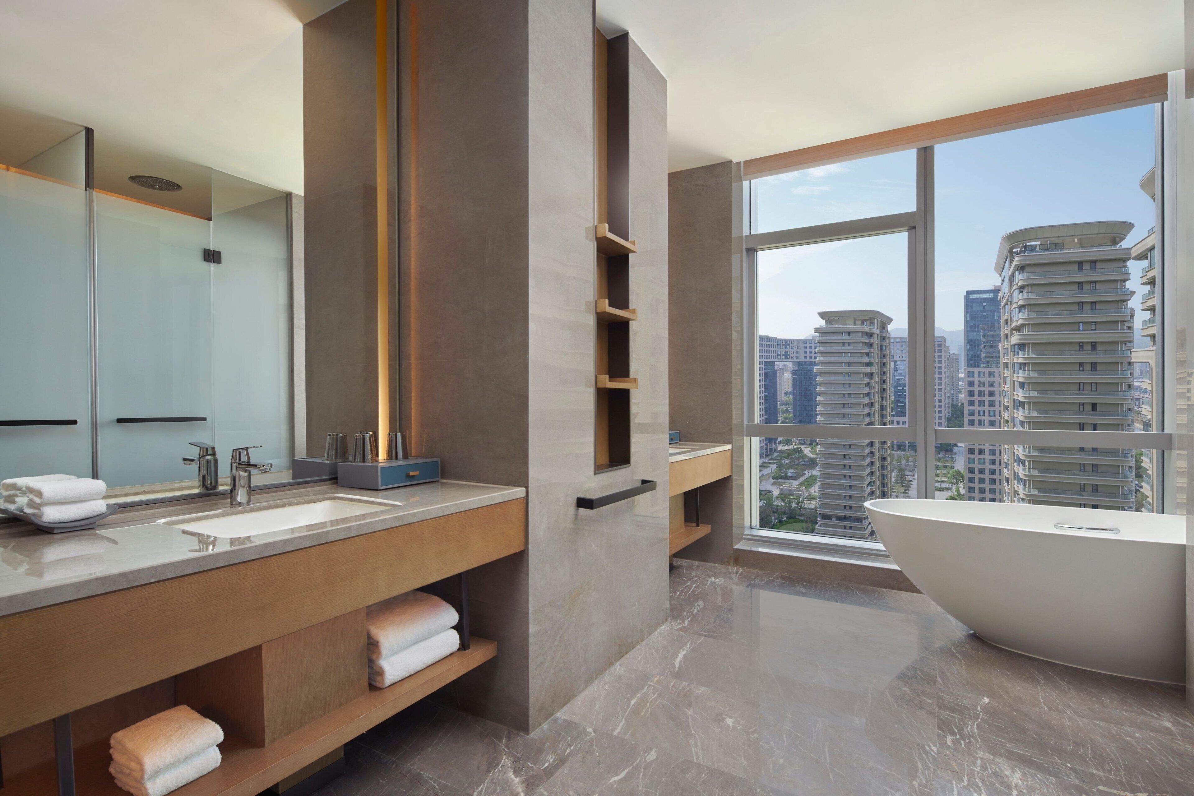 Un baño moderno con una bañera grande, un tocador doble y un espejo amplio.
