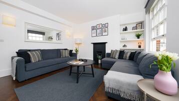 A modern living room with two grey sofas, a coffee table, and a fireplace.