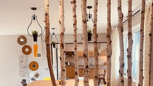 Uma sala de jantar moderna com divisórias de madeira de bétula, uma mesa e cadeiras.