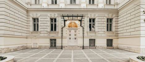 A courtyard with a central entrance, flanked by symmetrical windows and a decorative archway.