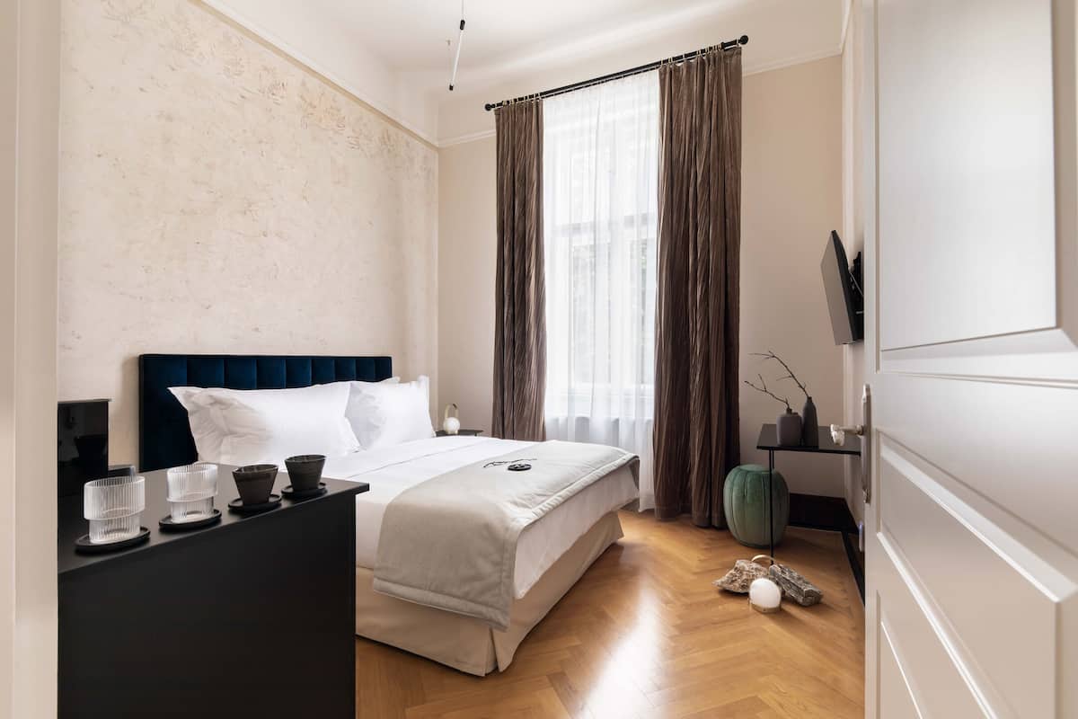 Une chambre bien rangée, avec un lit, une table de chevet et une commode.