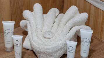 A wooden shelf with a white towel and three Ozone shampoo tubes.