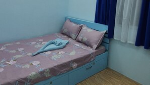 A bedroom with a bed, a nightstand, and a window with curtains. - Mistow BriaCondo City Center Area (Cagayan de Oro)