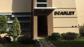 A building with a beige facade, multiple windows, and a sign reading "Scarlet". - Mistow BriaCondo City Center Area (Cagayan de Oro)