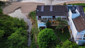 A coastal building with a flat roof, solar panels, and a small garden area. - Villa Tanderra (Kalametiya)