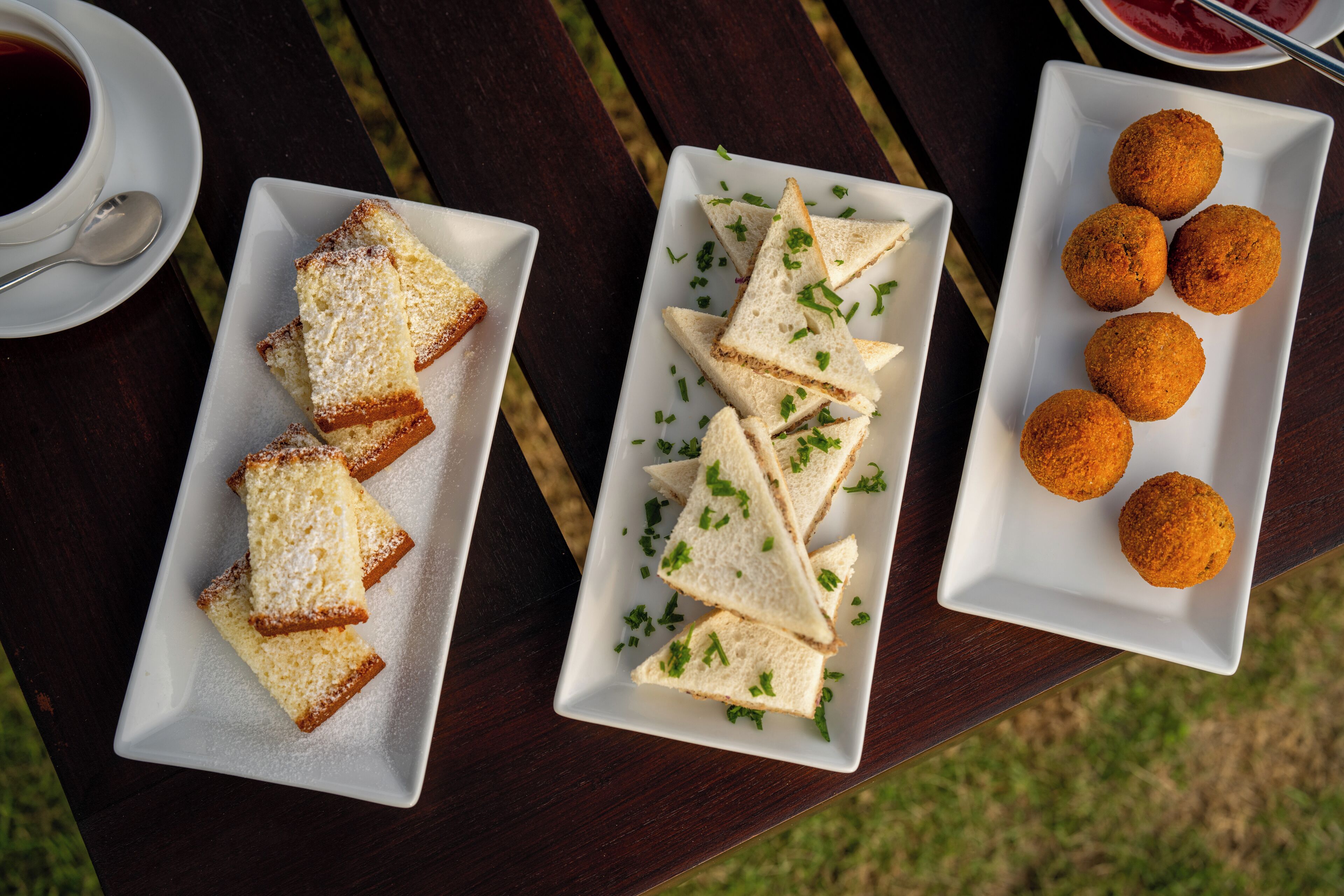 A table with three rectangular plates containing food items.