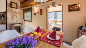 A wooden dining table with a red table runner, a clock on the wall, and a stone wall. - Modern family&pet friendly villa with private sauna and beach (Bosljiva Loka)