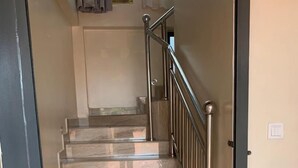 A staircase with a metal railing leading to a landing. - Avesta Hotel (Kampala)