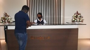 A reception desk with a person standing in front of it. - Avesta Hotel (Kampala)