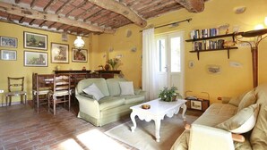 Ein gemütliches Wohnzimmer mit einem grünen Sofa, einem weißen Couchtisch und einem Bücherregal voller Bücher.