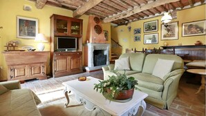 Ein gemütliches Wohnzimmer mit Kamin, Holzmöbeln und einem grünen Sofa.
