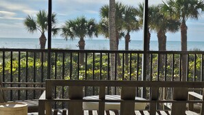 A balcony with a view of the ocean and palm trees. - Sanddollar C101: Gorgeous Reno & Decor Gulf-Front! (Sanibel)
