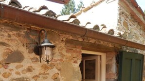 A stone building with a metal lantern, a wooden door, and a green shutter. - IL FORNO - Wonderful stone rustic house in the hills with breathtaking views. (Matraia)