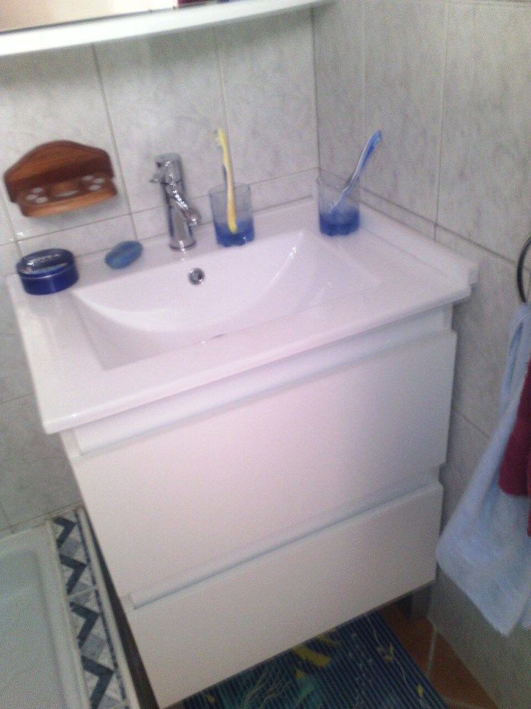 A bathroom with a white sink, a toothbrush holder, and a soap dish.