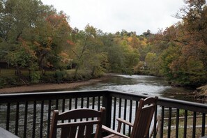 Une terrasse offrant une vue sur une rivière et les couleurs automnales des arbres.