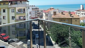 Un balcón con vistas a un pueblo costero, edificios y un cielo despejado.