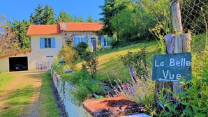 Ein rustikales Haus mit rotem Ziegeldach und einem Schild mit der Aufschrift 'La Belle Vue'.