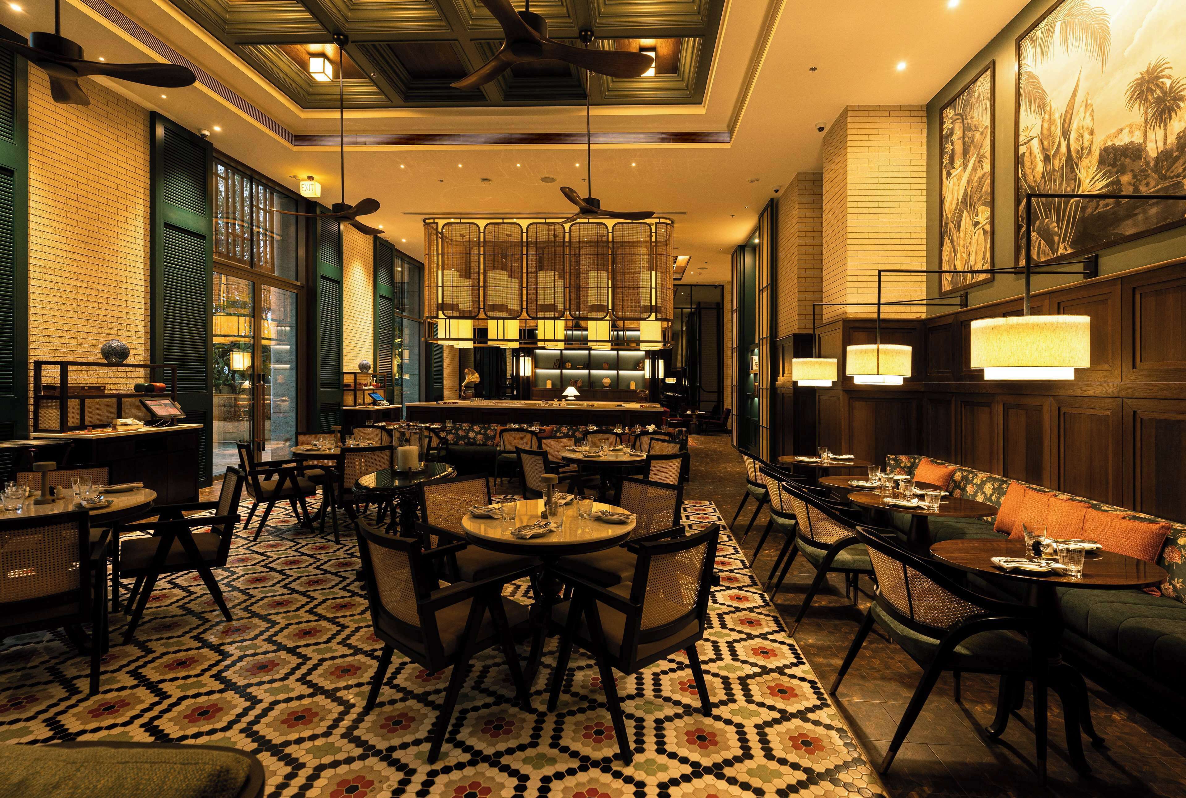 Un ristorante con tavoli rotondi, sedie e un pavimento decorato.
